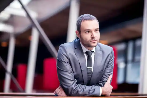 A business man stand simple and lloking for someone